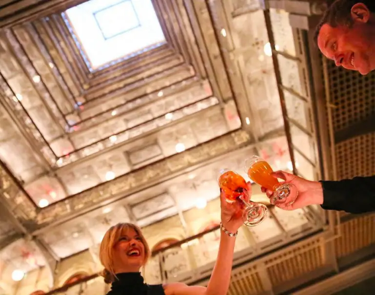 A couple smiling and cheering their glass full of juice