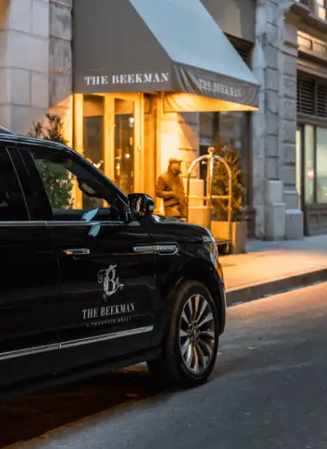 A vehicle is standing just beside the entrance of The Beekman Hotel