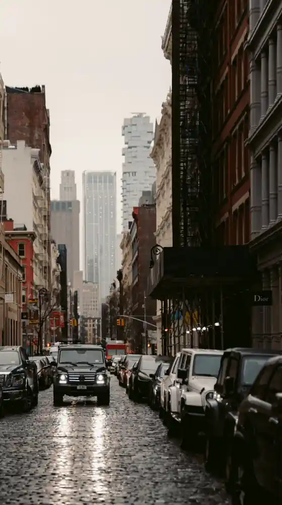 View of the street where vehicles are parked on both sides of the road
