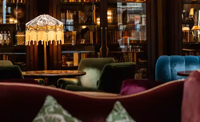 Beautiful stand lamp is lightning just beside the table in the library room