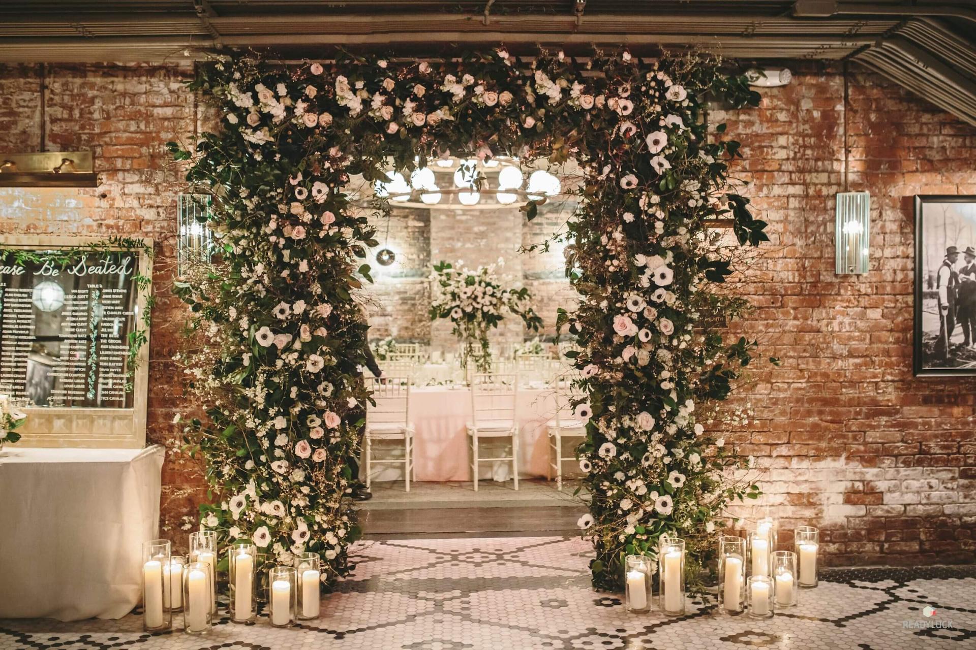 The entrance door is beautifully decorated with flowers, leaves, and glass candles